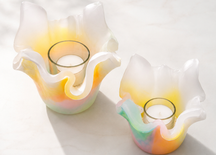 Zwei Lotus-Lichtfänge aus marmoriertem Wachs in sanften Polarlichtfarben mit eingesetztem Teelichtglas und heller Tageslichtstimmung.