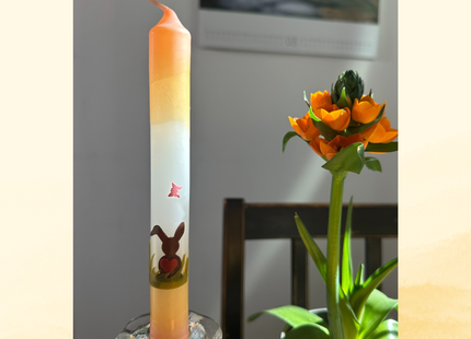 Handdekorierte Oster Stabkerze mit Hasenmotiv in Apricot-Weiß-Grün im Glasständer als frühlingshafte Tischdekoration