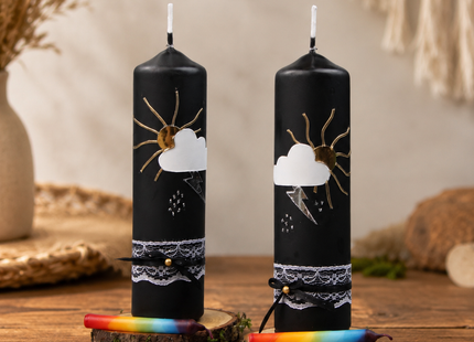 Zwei traditionelle Gewitterkerzen auf einem niedrigen Holztisch in einem gemütlichen Wohnzimmer, jeweils mit Birkenholzteller und Regenbogen-Fidibus.