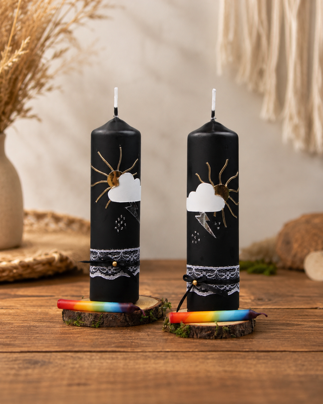 Zwei traditionelle Gewitterkerzen auf einem niedrigen Holztisch in einem gemütlichen Wohnzimmer, jeweils mit Birkenholzteller und Regenbogen-Fidibus.