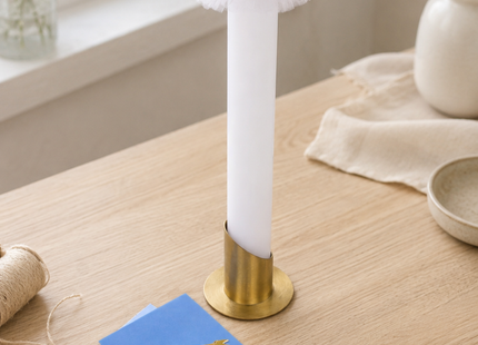 Blau-goldenes DIY Bastelset für eine Kommunionkerze auf hellem Holzarbeitstisch mit Kerzenrohling, Wachsplatten, Wachsfäden, Metallständer, Echtwachs-Motiven und Anleitung.