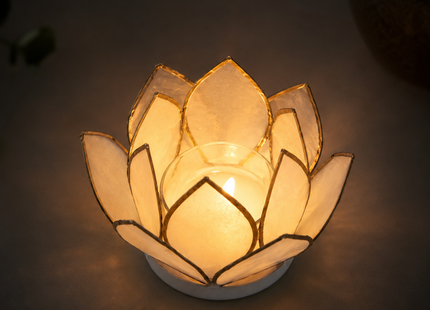 Weiß-goldenes Lotuslicht mit Teelicht in sanfter goldener Atmosphäre, als spirituelles Windlicht dekoriert.
