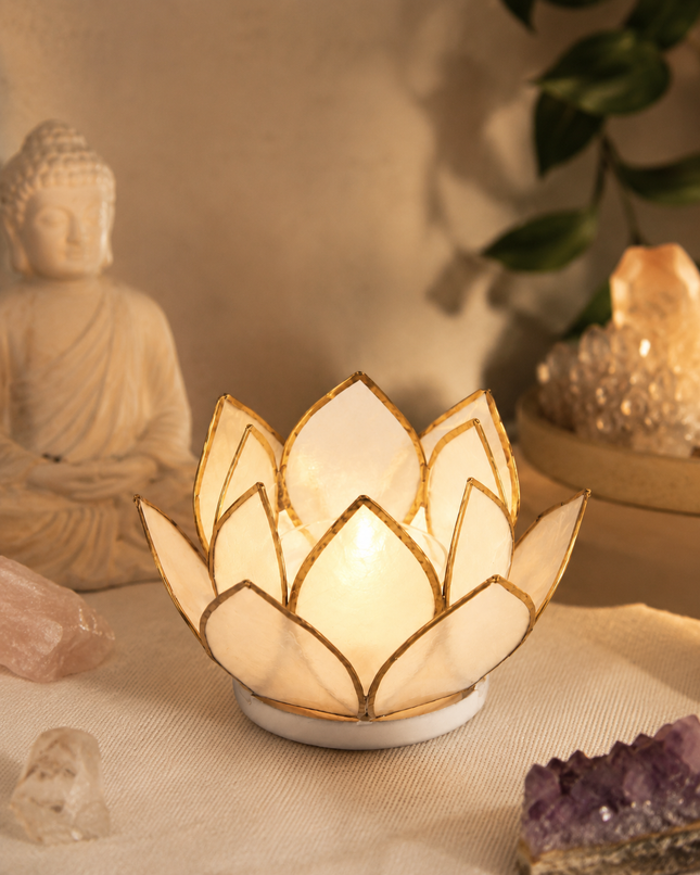 Leuchtendes weißes Lotus-Windlicht mit Goldrand im warmen Abendlicht, stimmungsvoll und meditativ inszeniert.