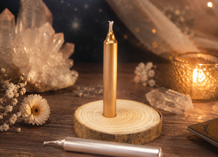 Orakel-Kerzen-Set mit goldener und silberner Ritualkerze auf natürlicher Holzscheibe, dekoriert mit Kristallen, Karten und warmem Kerzenlicht.