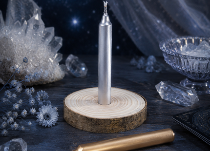Silberne Ritualkerze auf Holzscheibe mit goldener Kerze, Tannenzweigen, Kristallen und Kerzenlicht als Rauhnachts-Orakelset.