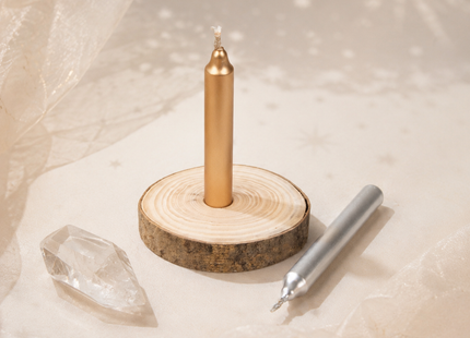 Goldene und silberne Ritualkerze mit Holzscheibe, Kristallen, Münze und Orakelkarten in magischer Ansicht von oben.