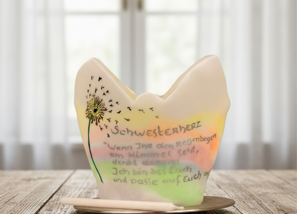 Lichtfang aus Wachs mit Pusteblume und Widmung auf einem Holztisch vor einem hellen Fenster.
