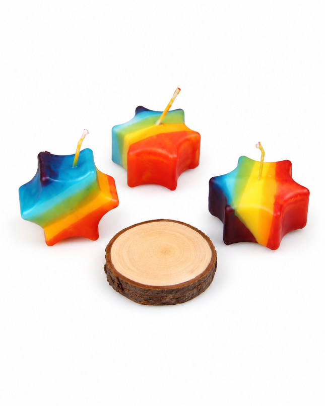 Kleine bunte Sternkerze im Regenbogen-Stil auf natürlicher Holzscheibe als Glücksstern und Hoffnungslicht.