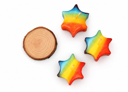 Set aus drei bunten Regenbogen-Sternkerzen mit natürlichem Holzteller, auch als Schwimmkerzen nutzbar.