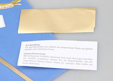 Nahaufnahme der Schreibfolie und Anleitung aus dem Kommunionkerzen Bastelset mit goldener und silberner Folie zum Beschriften der Kerze.