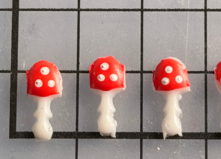 Kerze mit handgemachten Mini-Glückspilzen aus Wachs als zauberhafte DIY-Dekoration