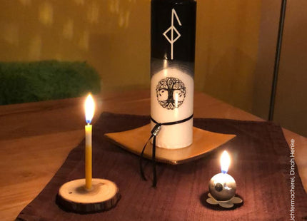 Runenkerze mit weißer Rune im schwarzen Wachsbereich – Symbol für Schutz und innere Balance
