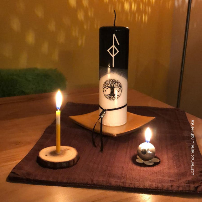 Runenkerze mit weißer Rune im schwarzen Wachsbereich – Symbol für Schutz und innere Balance
