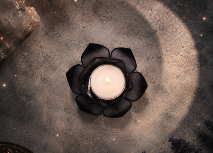 Nahaufnahme der filigranen Struktur des schwarzen Lotus-Teelichthalters mit Fokus auf den glänzenden, edlen Goldrand
